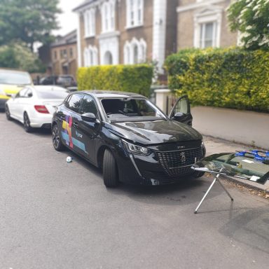A car parked on the roadside, showcasing Epic Windscreens glass repair service nearby.